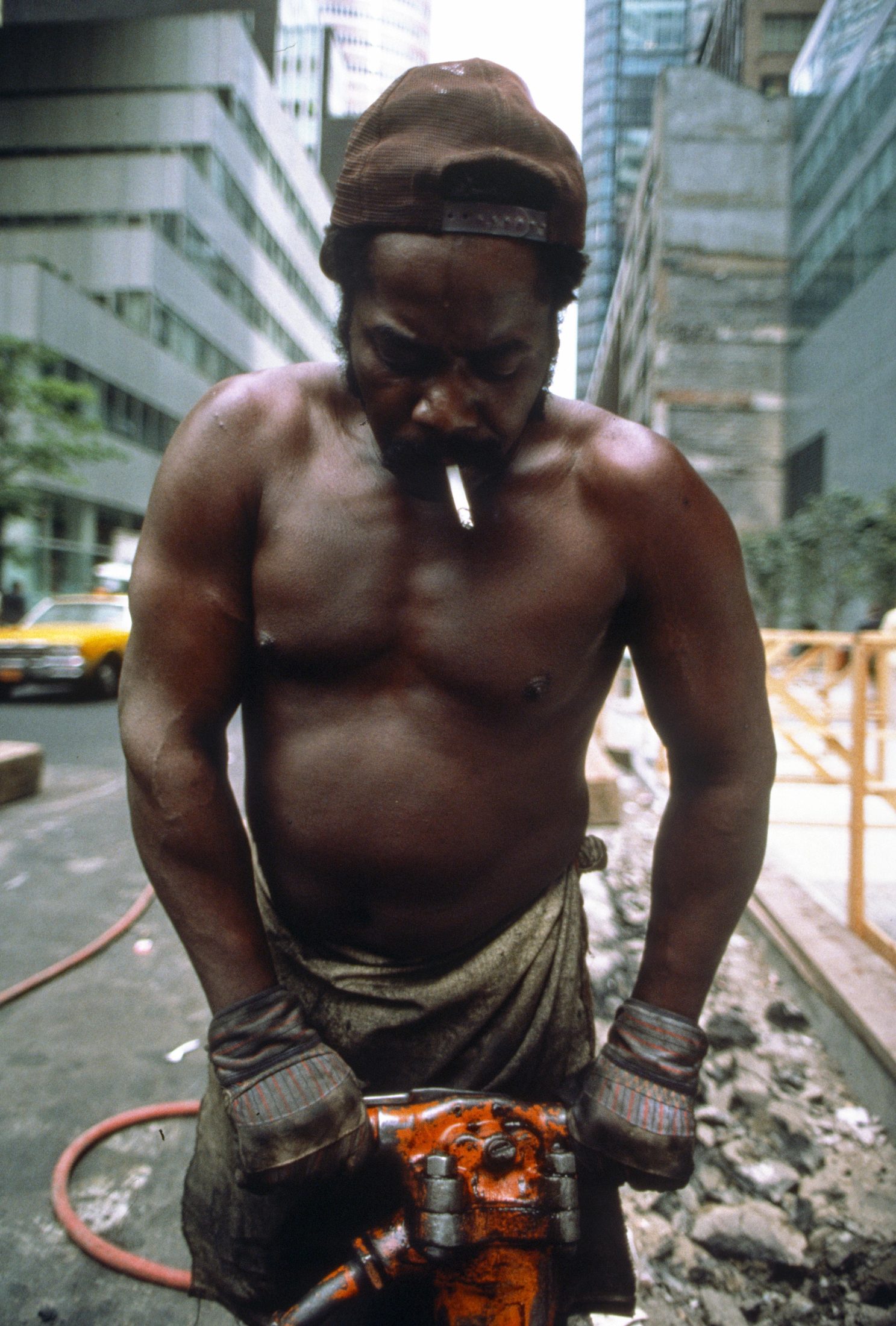Construction worker portrait with jackhammer, high-rise site