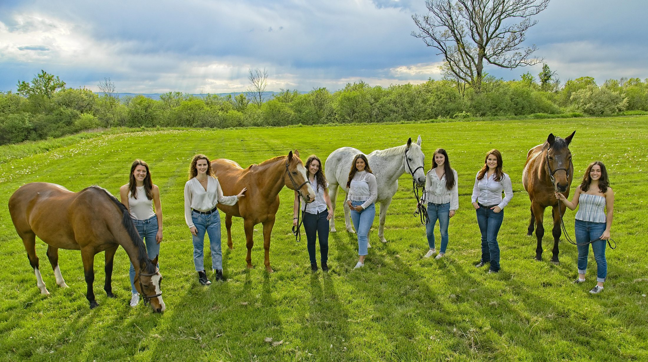 Cornell Equestrian team, wide group portrait with horses