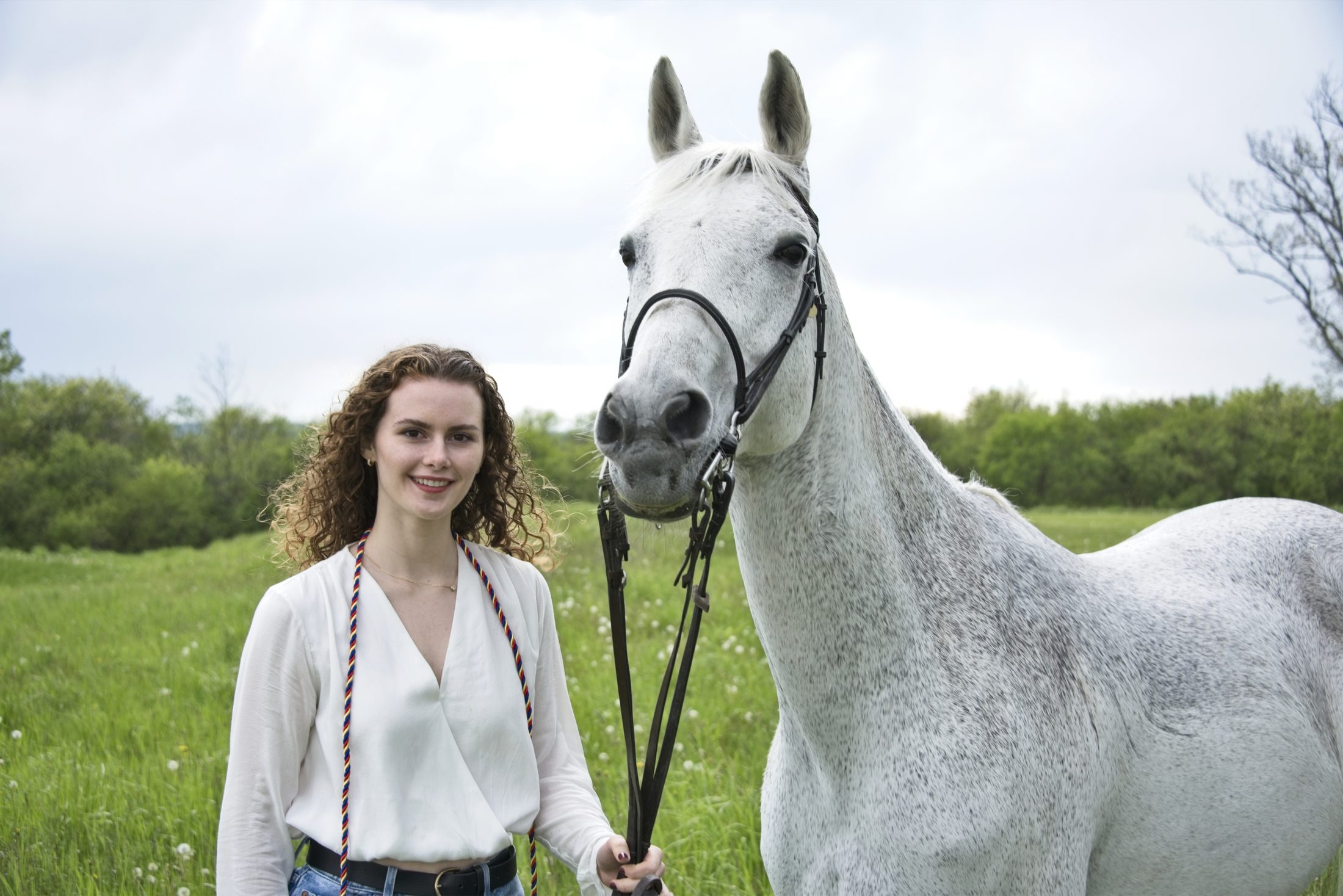Cornell Equestrian team rider with a gray horse, portrait