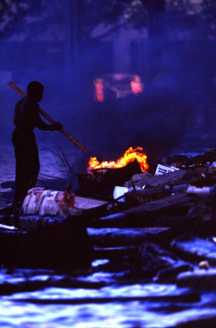 Man warming himself by a fire at night, without shelter