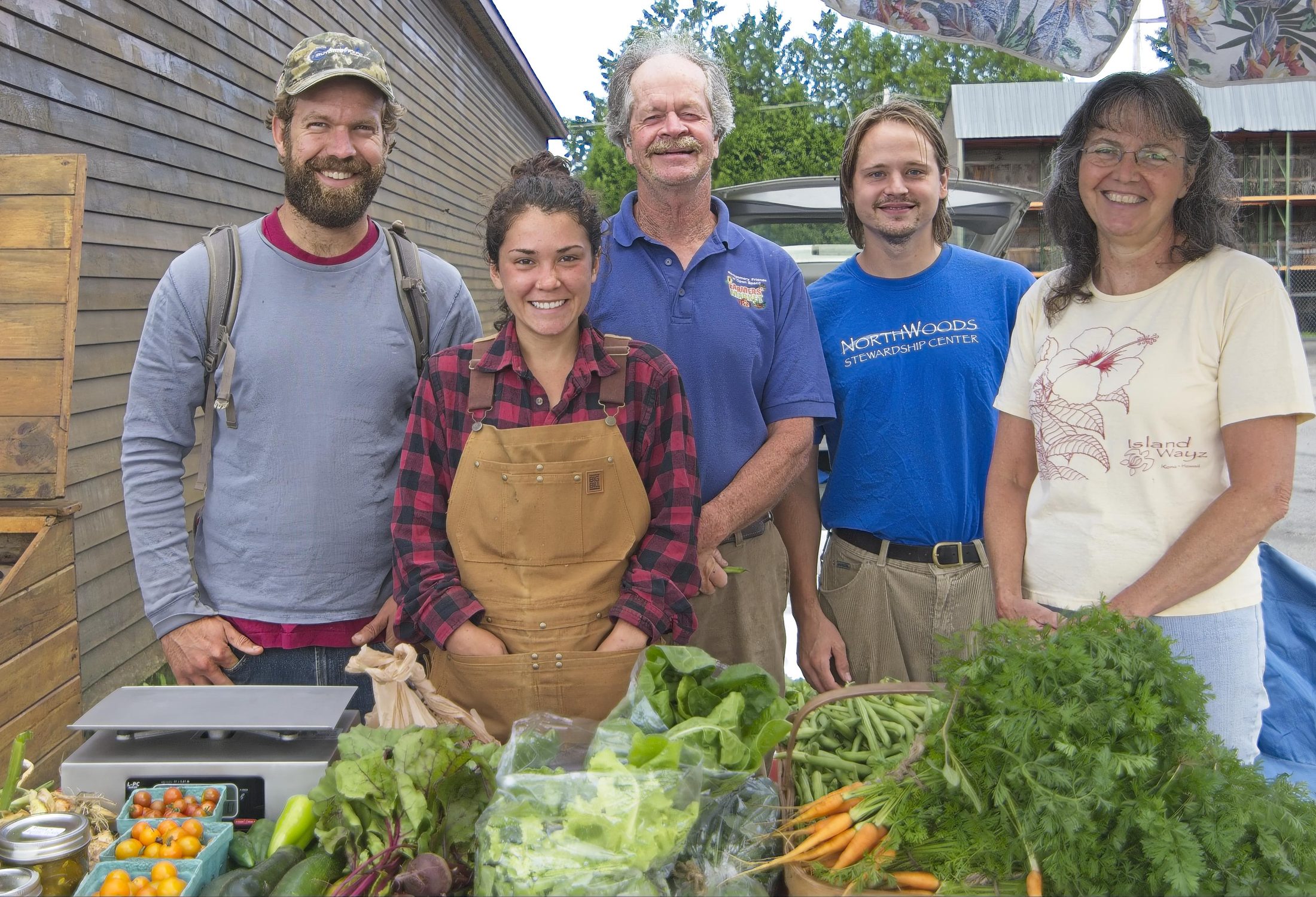 Group portrait of farmers market vendors with produce