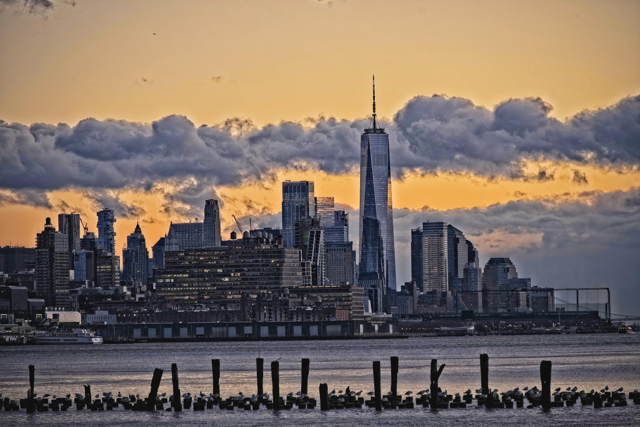 Lower Manhattan skyline at dusk, seen from the harbor