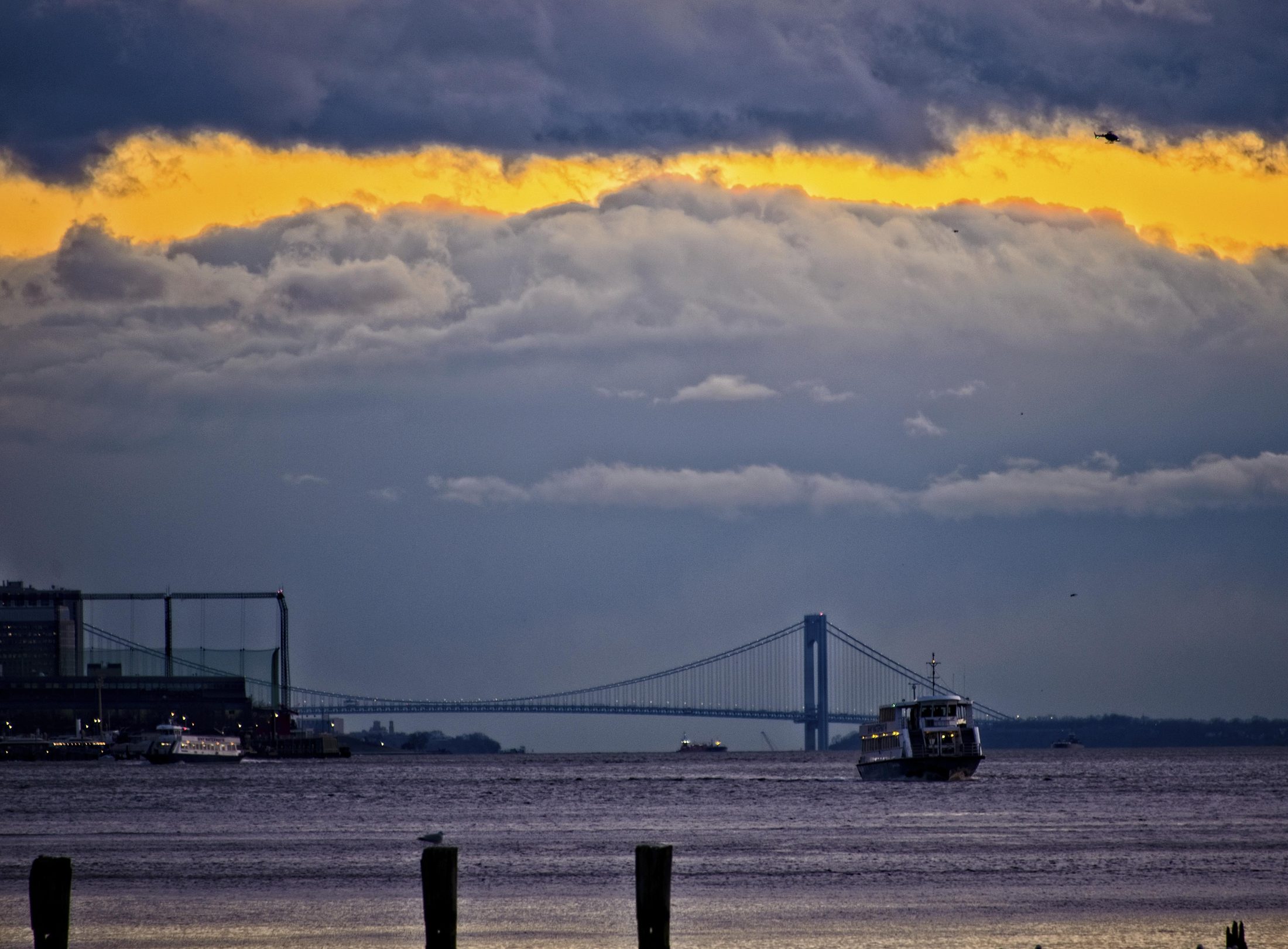 Ferry passing the Verrazzano-Narrows Bridge at dusk
