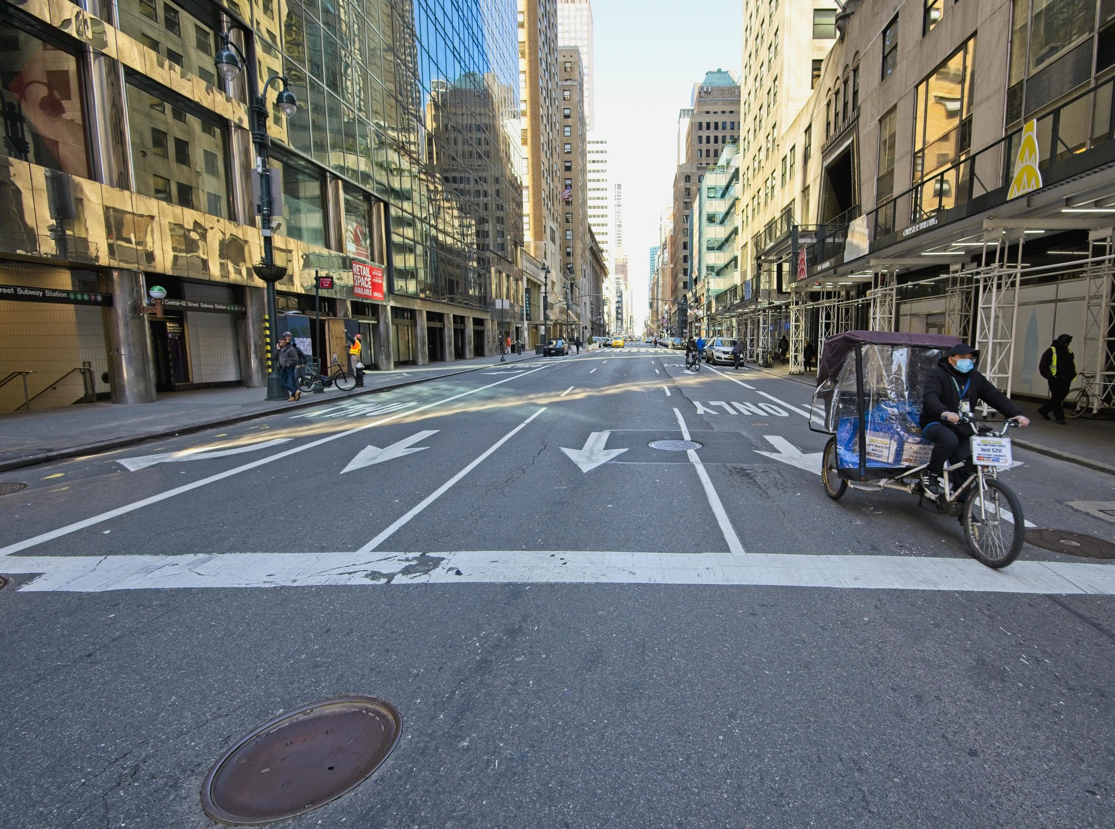 Empty Manhattan street with a masked pedicab rider